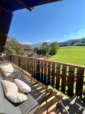 a deck with chairs and a view of a field at Appartement Champêtre - Terrasse, Vue & Parking by AlpenlySallanches in Domancy