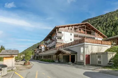a large building in the snow with snow covered roads at l'Ours Bleu B13 - Ski In Ski Out in Vallorcine