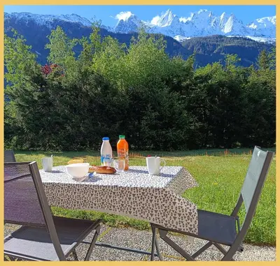 a table with food and drinks on it with mountains at L'Aiguille de Chamonix I Appartement Les Praz in Chamonix-Mont-Blanc