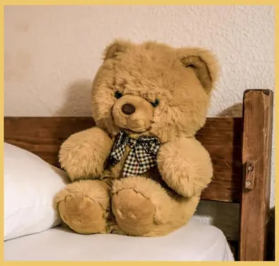 a teddy bear sitting on top of a bed at L'Aiguille de Chamonix I Appartement Les Praz in Chamonix-Mont-Blanc
