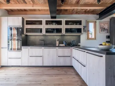 a kitchen with white cabinets and a wooden ceiling at Chalet Zazen I Le Chalet Club in Combloux