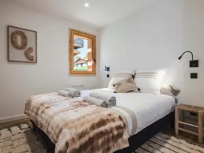 a bedroom with a large bed with a blanket on it at Chalet Zazen I Le Chalet Club in Combloux