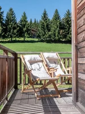 a couple of chairs sitting on a deck at Chalet Zazen I Le Chalet Club in Combloux