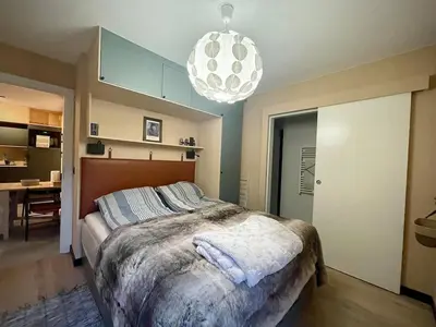 a bedroom with a large bed and a chandelier at Elba, Les Mazots de Kayla in Les Houches