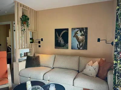 a living room with a couch and paintings on the wall at Elba, Les Mazots de Kayla in Les Houches