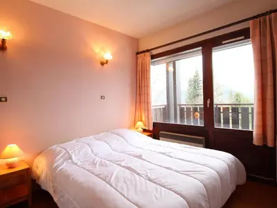 a bedroom with a large bed and a large window at 3 Pièces aux Carroz, 6 Pers, Terrasse, Parking - FR-1-572-338 in Arâches-la-Frasse