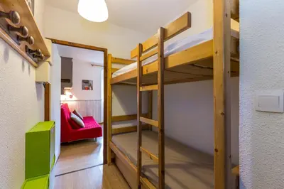 a room with bunk beds and a red couch at Les Sommets Studio in Chamonix-Mont-Blanc