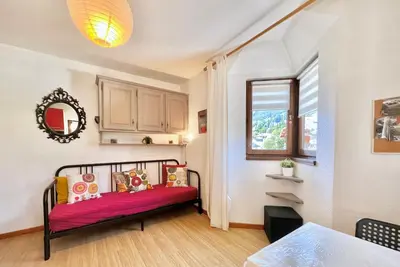 a small room with a bed and a window at Les Sommets Studio in Chamonix-Mont-Blanc
