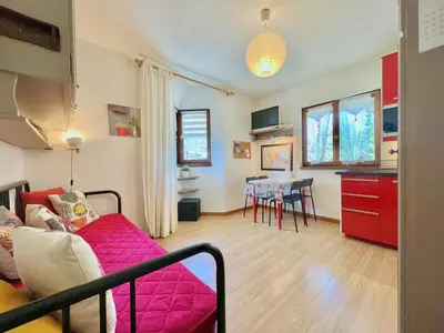 a living room with a red couch and a table at Les Sommets Studio in Chamonix-Mont-Blanc