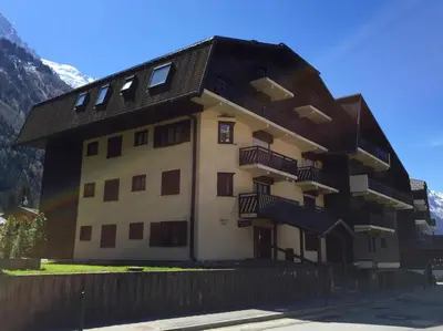 a building with a black roof and balconies on it at Les Sommets Studio in Chamonix-Mont-Blanc