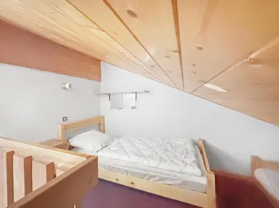 a small room with a bed and a staircase at BA229 - 2 pieces mezzanine 6 pers pied de pistes in Les Carroz d'Araches