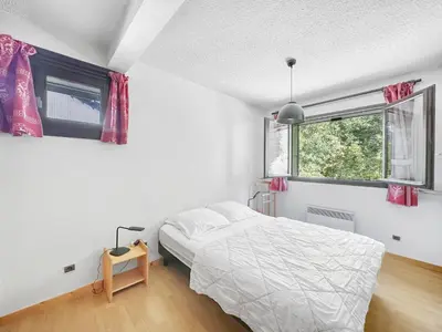 a white bedroom with a bed and a window at BA229 - 2 pieces mezzanine 6 pers pied de pistes in Les Carroz d'Araches