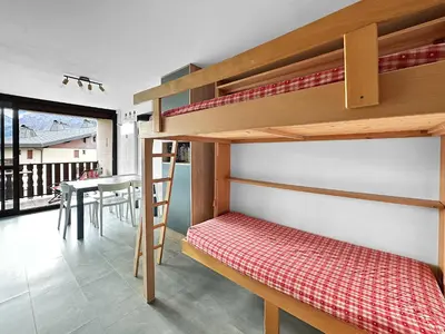 a bunk bed in a room with a table at PLAT113 - Studio 4 pers centre station Carroz in Les Carroz d'Araches