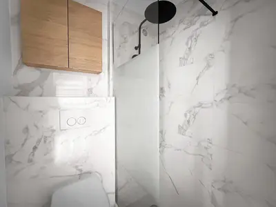 a white bathroom with a toilet and a cabinet at PLAT113 - Studio 4 pers centre station Carroz in Les Carroz d'Araches