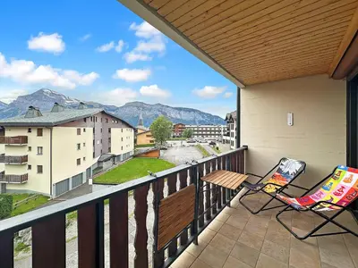 a balcony with two chairs and a view of mountains at PLAT113 - Studio 4 pers centre station Carroz in Les Carroz d'Araches
