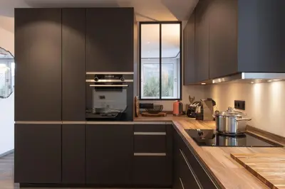 a kitchen with black cabinets and a stove at Quartz - Appt 4 etoiles vue Mont-Blanc - Centre in Chamonix-Mont-Blanc