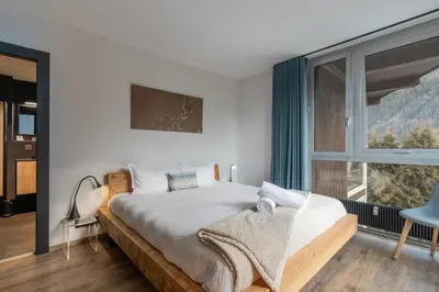 a bedroom with a bed and a large window at Quartz - Appt 4 etoiles vue Mont-Blanc - Centre in Chamonix-Mont-Blanc