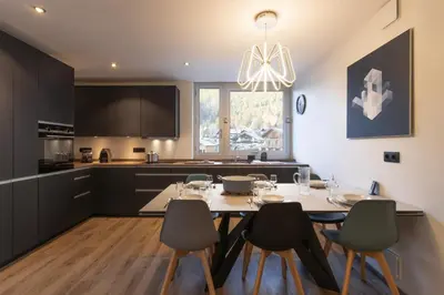 a kitchen and dining room with a table and chairs at Quartz - Appt 4 etoiles vue Mont-Blanc - Centre in Chamonix-Mont-Blanc
