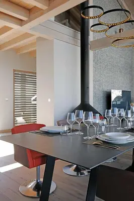 a dining table with wine glasses and a stove at JAMES TAMG31 - luxury design chalet Megeve in Combloux