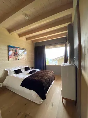 a bedroom with a large bed and a window at JAMES TAMG31 - luxury design chalet Megeve in Combloux