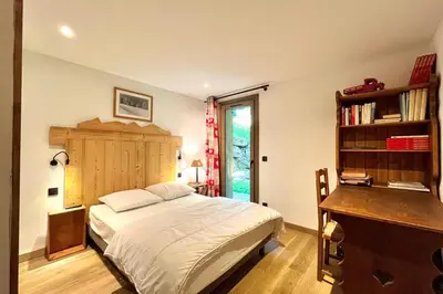 a bedroom with a bed and a desk and a book shelf at Cozy chalet in Combloux near the slopes in Combloux