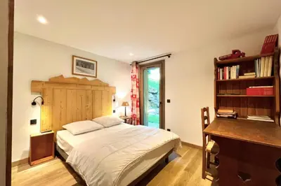 a bedroom with a bed and a desk and a window at Cozy chalet in Combloux near the slopes in Combloux