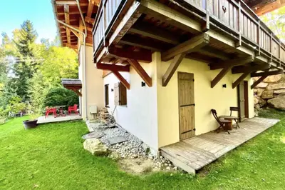 a house with a porch and a grass yard at Cozy chalet in Combloux near the slopes in Combloux