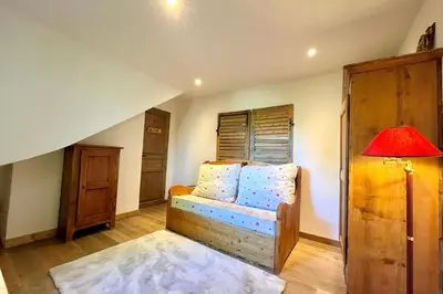 a room with a bed with a lamp and a window at Cozy chalet in Combloux near the slopes in Combloux