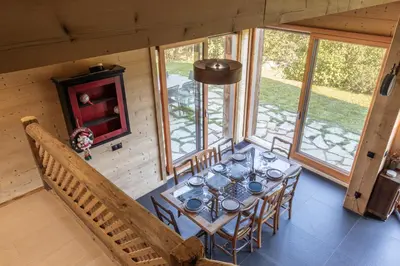 a dining room with a table and chairs in a cabin at Appt Vincent - 200 m2 - Ideal famille - Vue Mont-B in Cordon