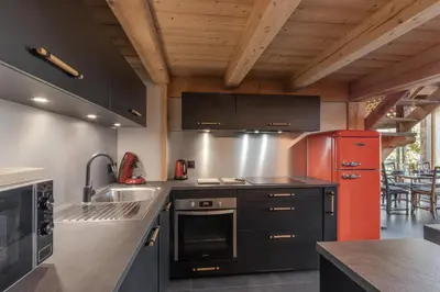 a kitchen with a red refrigerator and a sink at Appt Vincent - 200 m2 - Ideal famille - Vue Mont-B in Cordon