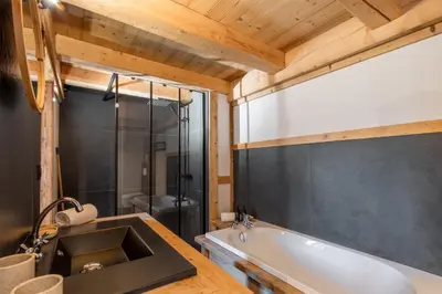 a bathroom with a bath tub and a sink at Appt Vincent - 200 m2 - Ideal famille - Vue Mont-B in Cordon