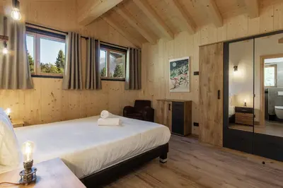 a bedroom with a large bed and a mirror at Chalet La Source - Ideal familles ski et rando in Chamonix-Mont-Blanc