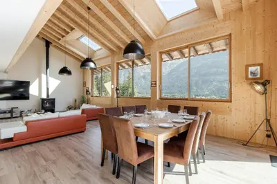 a dining room with a table and a couch at Chalet La Source - Ideal familles ski et rando in Chamonix-Mont-Blanc