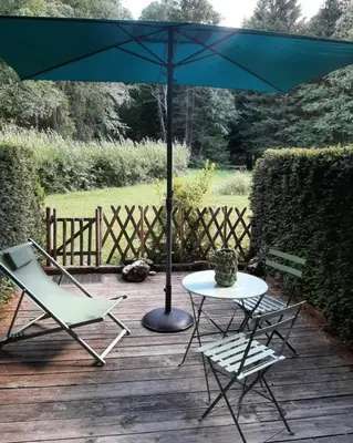 a table and two chairs and an umbrella on a deck at Le Roffie-lan in Les Contamines-Montjoie