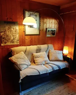 a couch sitting in a room with a lamp at Le Roffie-lan in Les Contamines-Montjoie