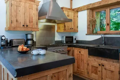 a kitchen with wooden cabinets and a counter top at Chalet Martinique - Chamonix All Year in Chamonix-Mont-Blanc