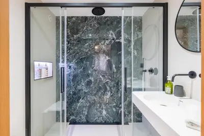 a blue tiled bathroom with a toilet and a window at Chalet Scandinave - Ski-in out Piste Flegere - Next to Golf - By Cozee Rentals in Chamonix-Mont-Blanc