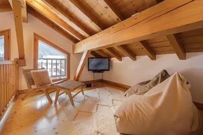 a bedroom with bunk beds with a chair and a desk at Chalet Scandinave - Ski-in out Piste Flegere - Next to Golf - By Cozee Rentals in Chamonix-Mont-Blanc
