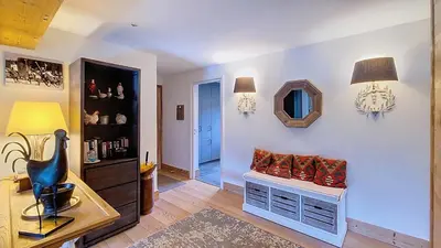 a living room with a bench and a mirror at 1 Sunshine - PROCHE CENTRE - in Megève