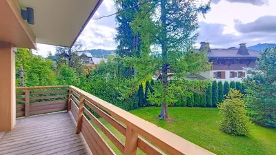 a wooden balcony with a view of a yard at 1 Sunshine - PROCHE CENTRE - in Megève