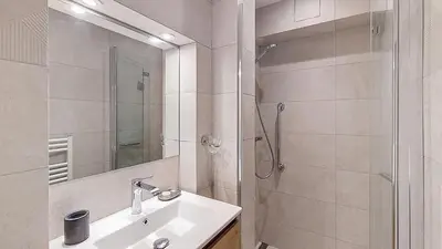 a white bathroom with a sink and a shower at 1 Sunshine - PROCHE CENTRE - in Megève