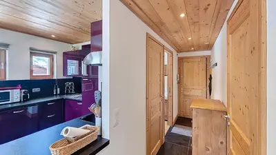 a kitchen with purple cabinets and a wooden ceiling at 1 Peupliers - CENTRE du VILLAGE - in Megève