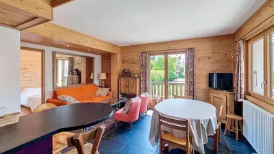 a living room with a table and a couch at 1 Peupliers - CENTRE du VILLAGE - in Megève