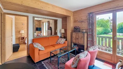a living room with an orange couch and chairs at 1 Peupliers - CENTRE du VILLAGE - in Megève