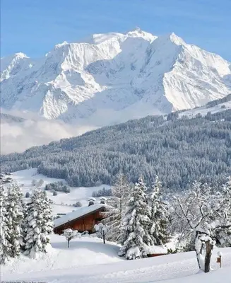 a cabin in the snow with a snow covered mountain at Chalet neuf La Marmotière - Vue sur la Montagne in Combloux