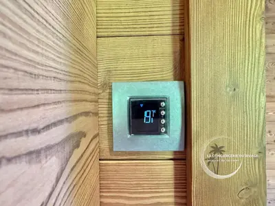 a lightswitch on a wooden door with a clock on it at Chalet neuf La Marmotière - Vue sur la Montagne in Combloux