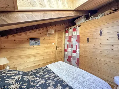 a bedroom with a bed in a wooden wall at PE317 - 4 pieces 6 a 7 pers proximite centre in Les Carroz d'Araches