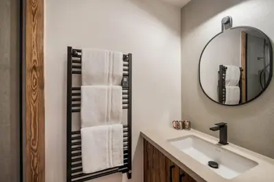 a bathroom with a sink and a mirror at Luxury Chalet Black Mountain - 4BR, Sleeps 10, Fireplace, Mountain Views & Garden - Megève in Megève