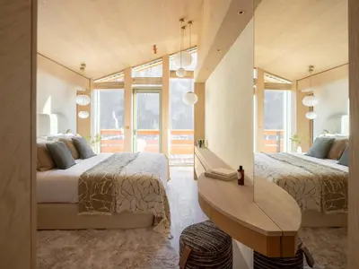 a bedroom with two beds and a wooden table at Chalet Acorn in Chamonix-Mont-Blanc