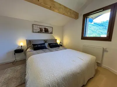 a bedroom with a white bed with a window at Duplex élégant au centre, vue vallée, confort moderne - FR-1-624-185 in Samoëns